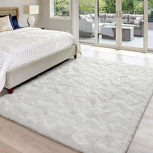 Bedroom with a white rug and sliding glass doors to a patio.