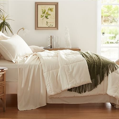 Cozy bedroom with white bedding and green throw blanket.