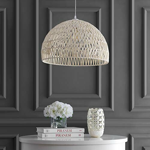 Woven pendant light above a table with flowers and books.